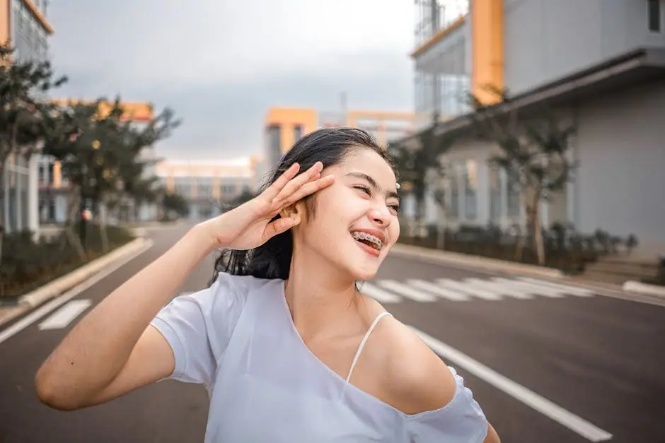 Happy woman with braces smiling on an urban street in daylight.