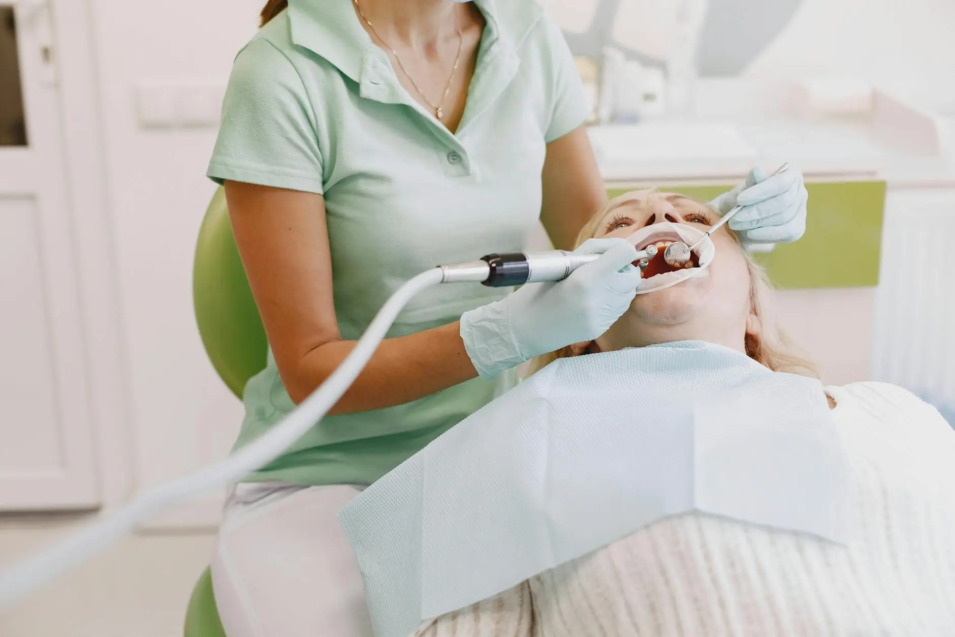 Dentist performing an oral examination on a patient in a clinic setting.