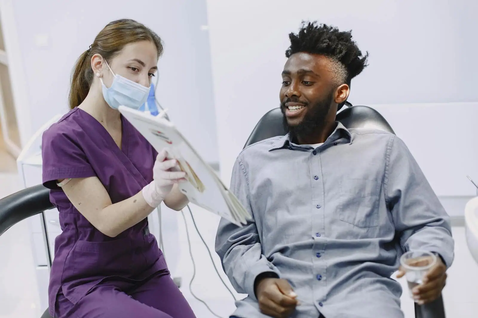 A dentist explains treatment options to a patient during a checkup.