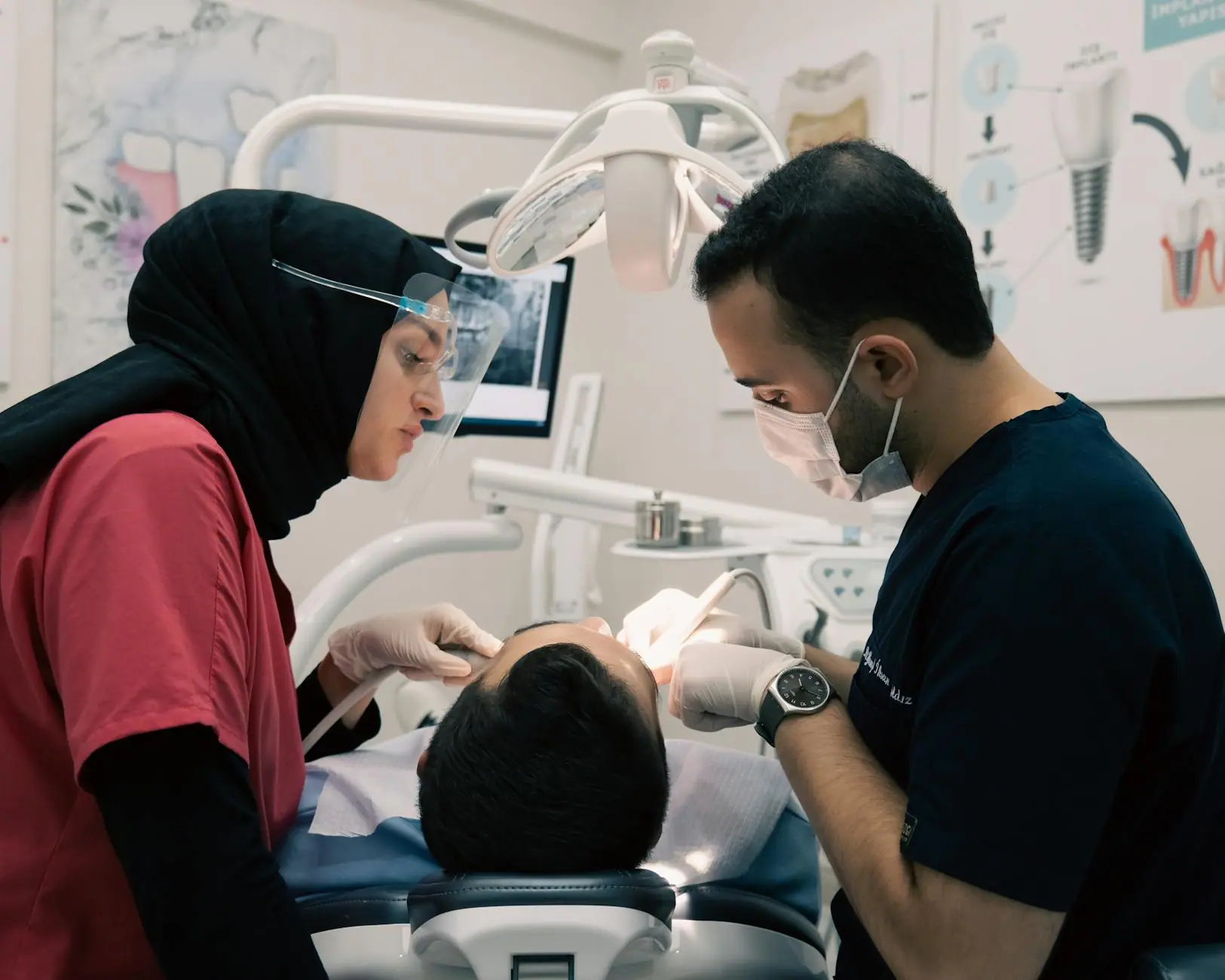 Dentist and assistant providing dental care to a patient with advanced equipment in a modern clinic.